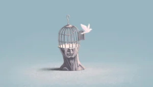bird escaping cage shaped like the human head or mind